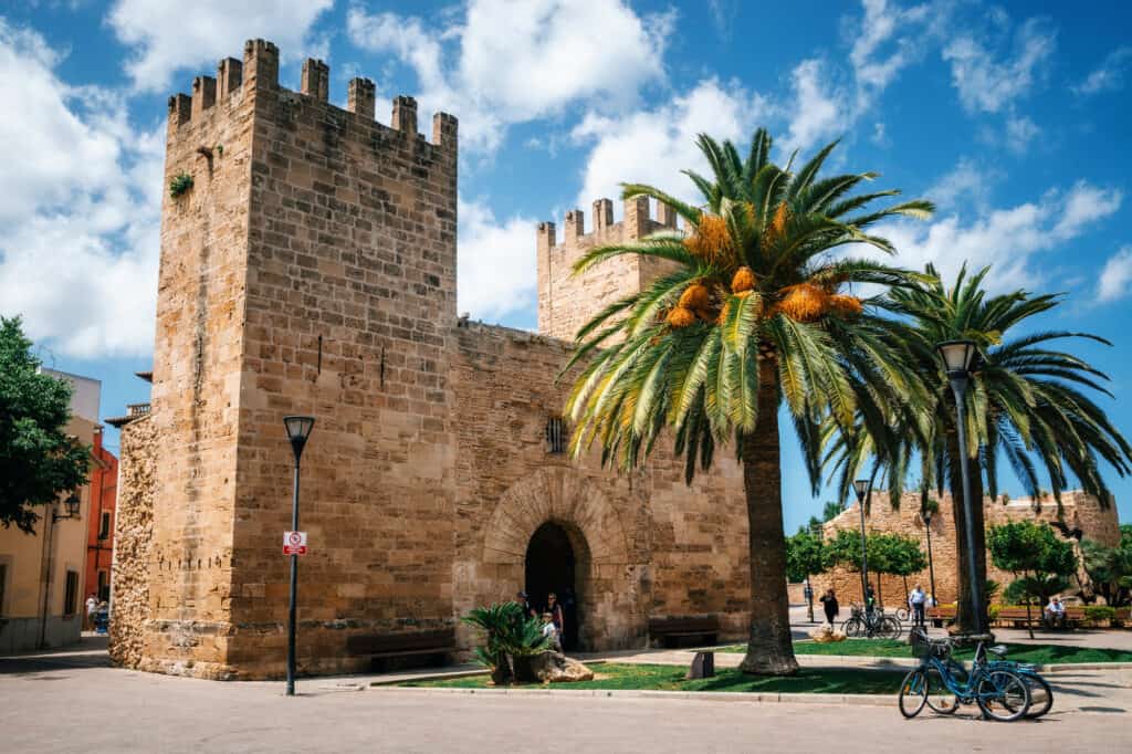 A stone building with a palm tree in Mallorca.