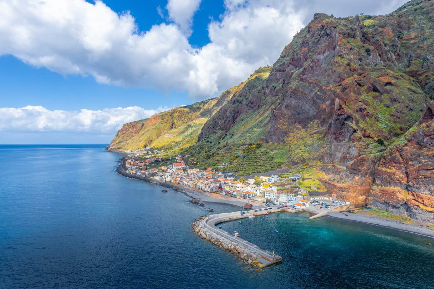 An aerial view of a village on a cliff overlooking the ocean in Madeira.