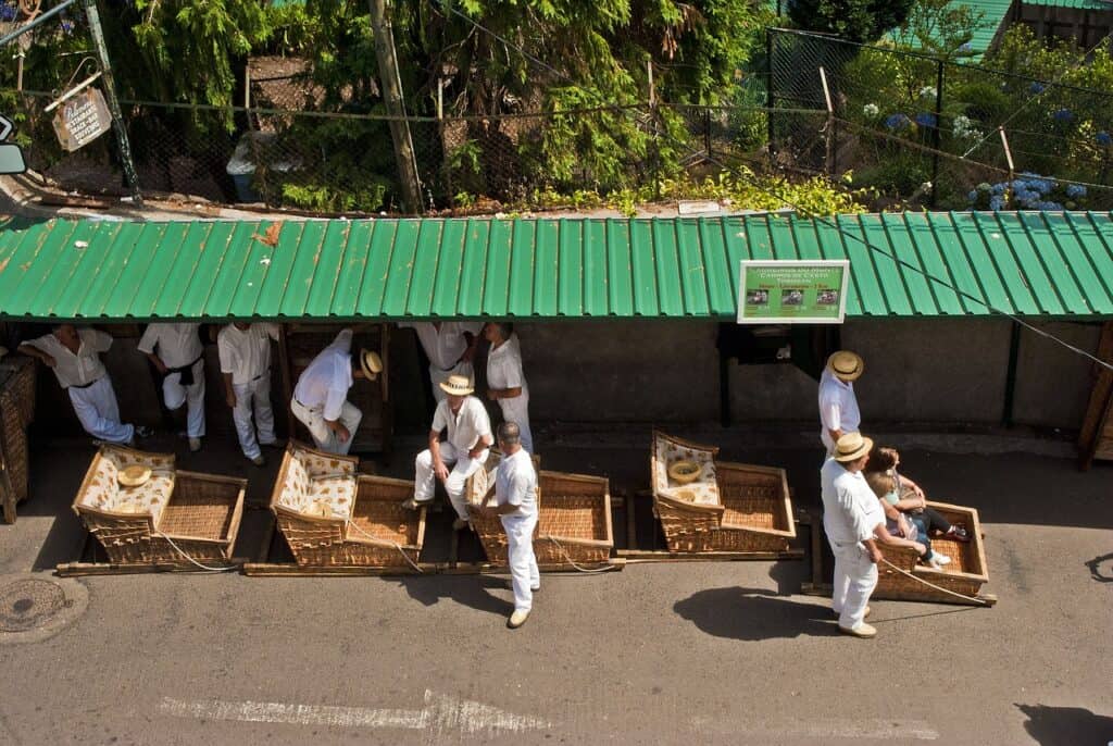 A group of men carrying crates on a street.