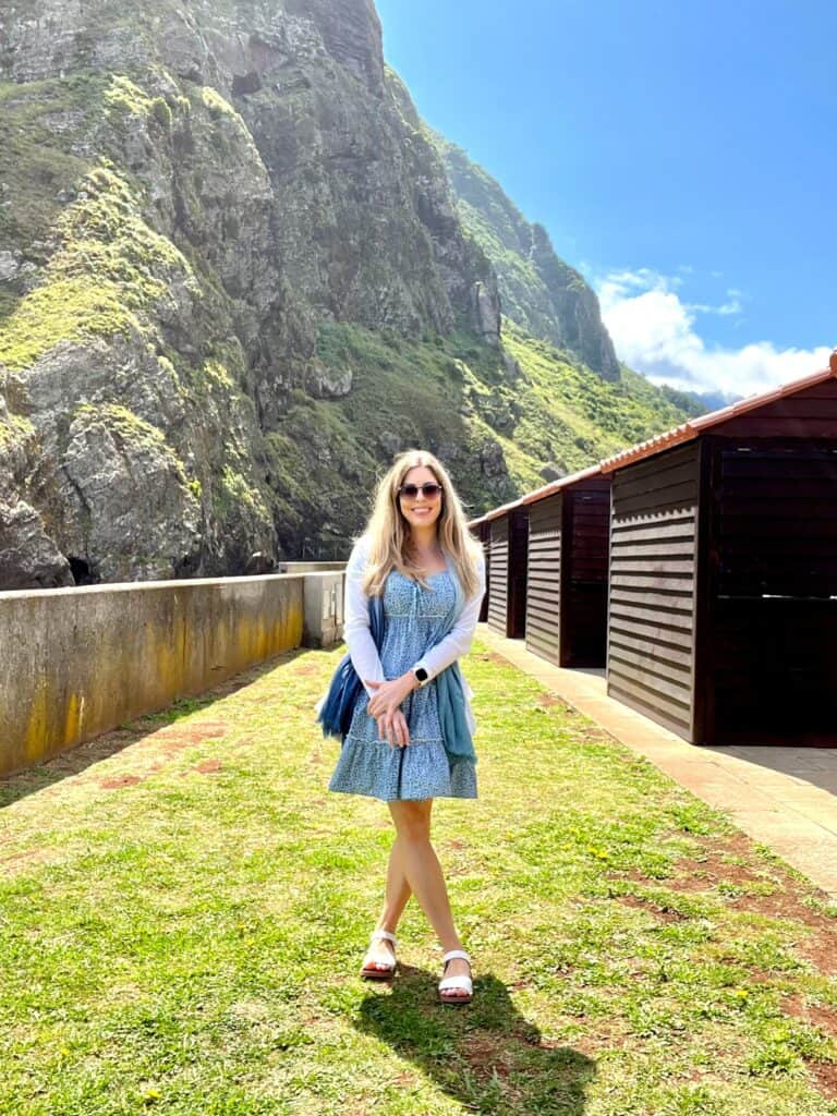 A woman in a blue dress in front of a grassy area on a Madeira itinerary.
