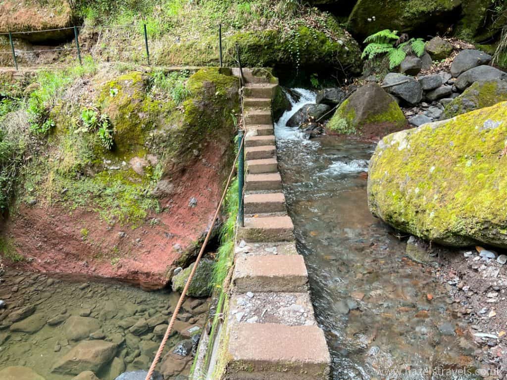 Steps leading to a stream in a rocky area.