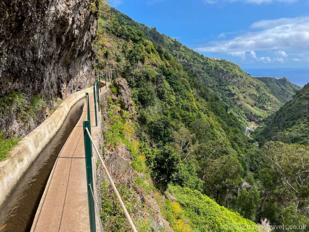 A walkway leading up to a cliff with a view of the ocean from levada do moinho, Madeira.