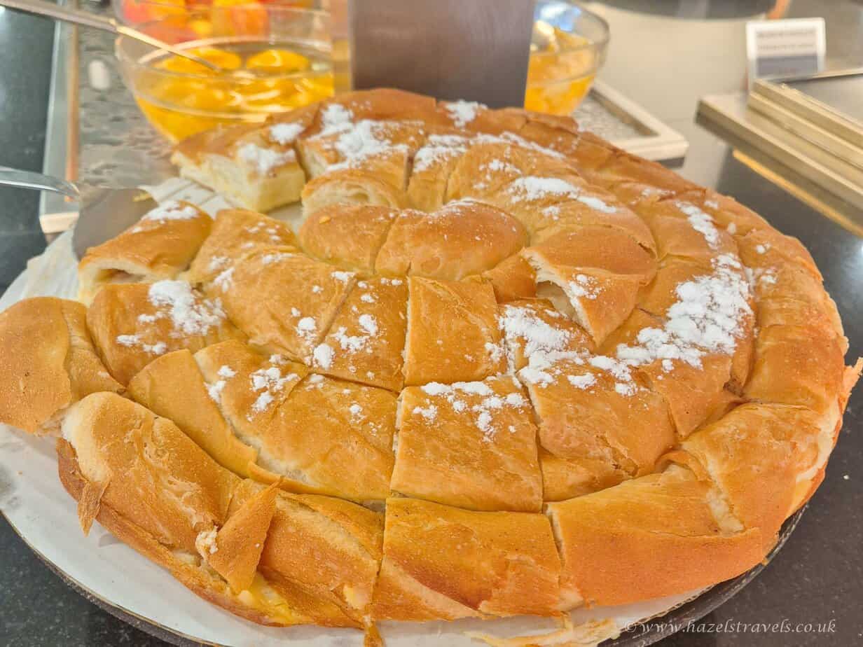 Creamy Italian cheese-filled bread, fresh and sliced, served with sweet peach slices in syrup for a delightful dessert experience. Suitable for travel and food enthusiasts.